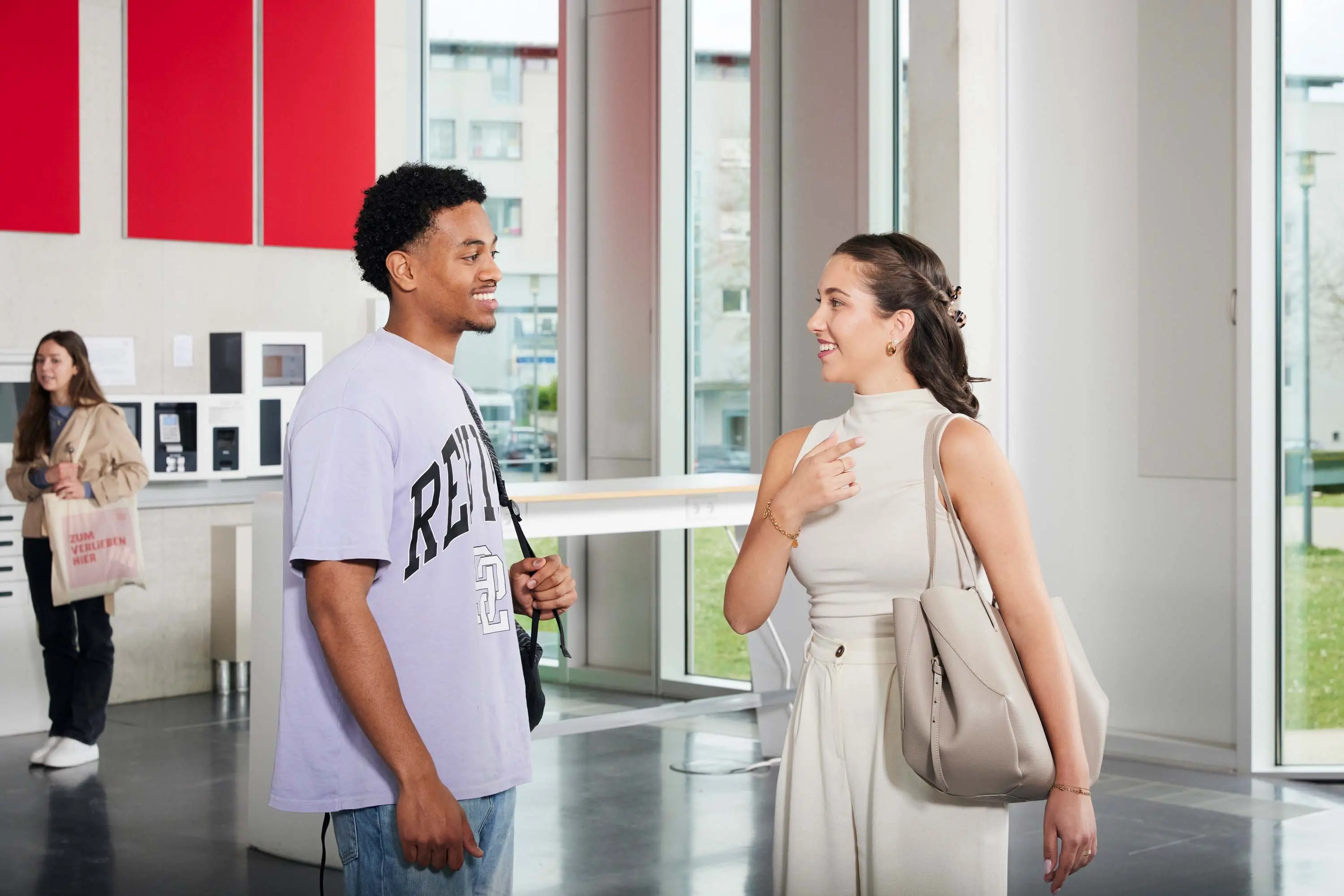 Zwei Studierende unterhalten sich auf dem Campus.