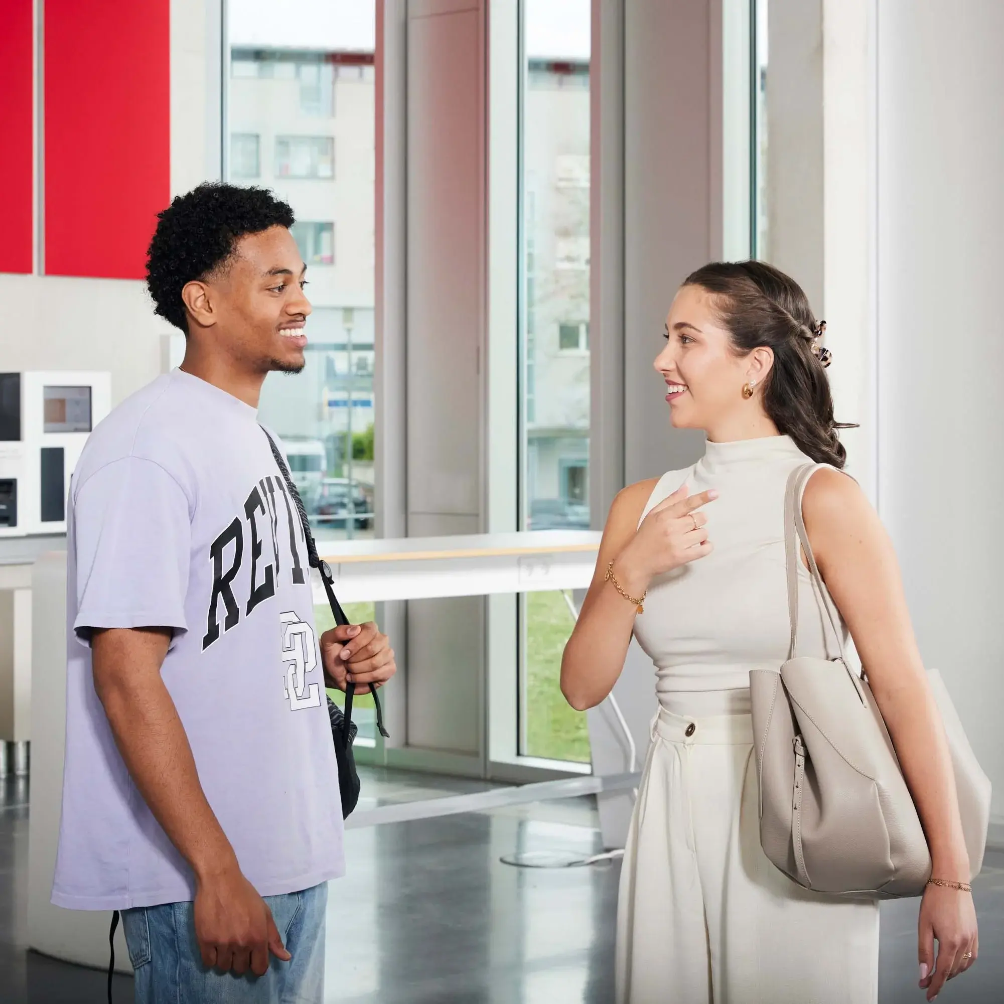 Zwei Studierende unterhalten sich auf dem Campus.