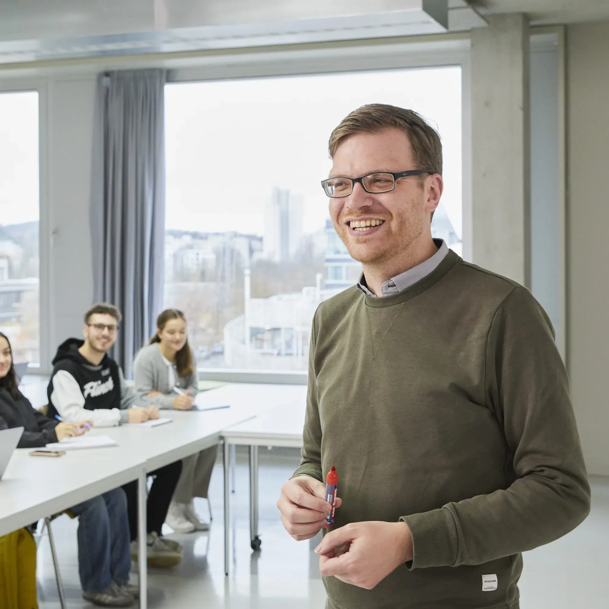 Ein Professor mit seinen Studierenden in der Vorlesung.