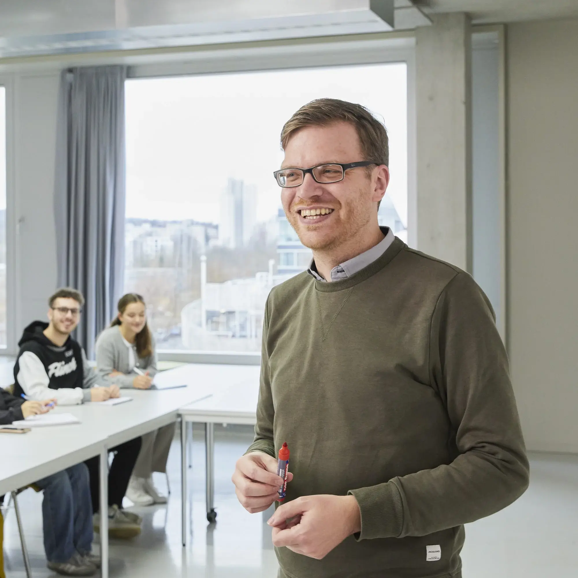 Ein Professor mit seinen Studierenden in der Vorlesung.