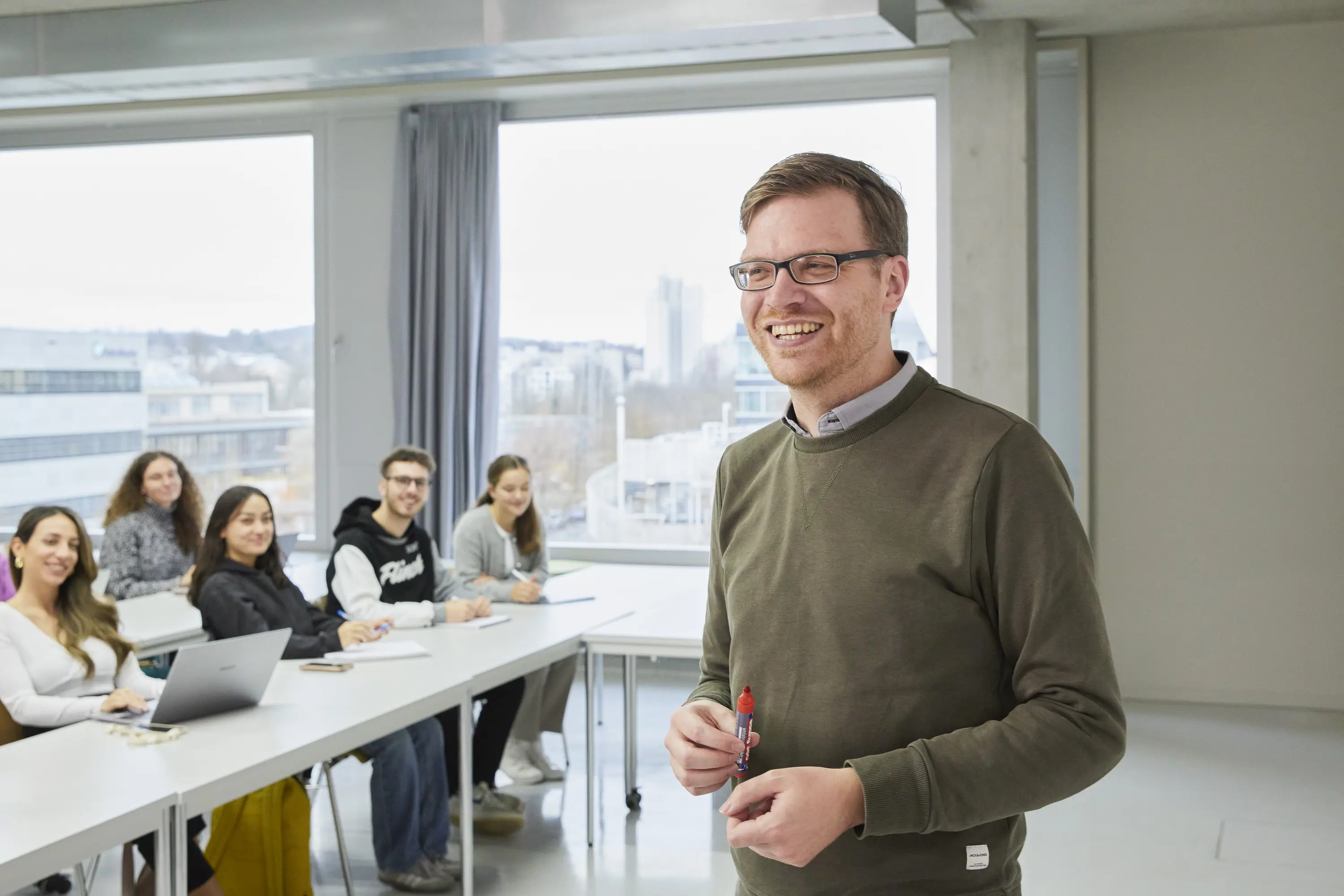 Ein Professor mit seinen Studierenden in der Vorlesung.